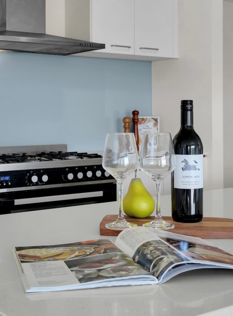 two glass beside wine bottle and a pear fruit