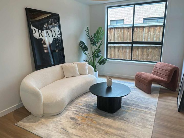 A well-decorated living room showcasing a plush couch, a trendy chair, and a contemporary table, ideal for home staging.