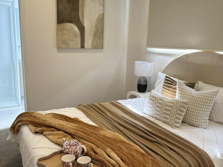 Stylish home-staged bedroom with a bed, a coffee tray, and an art piece enhancing the ambiance.